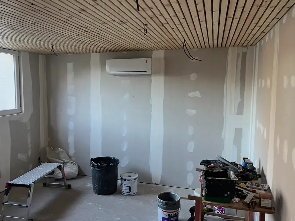 Pièce en travaux : cloisons en plaques de plâtre aux joints enduits de bandes, plafond en lames de bois clair